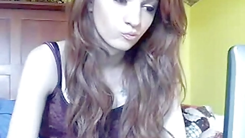 A pretty girl is playing with her fingers on a table